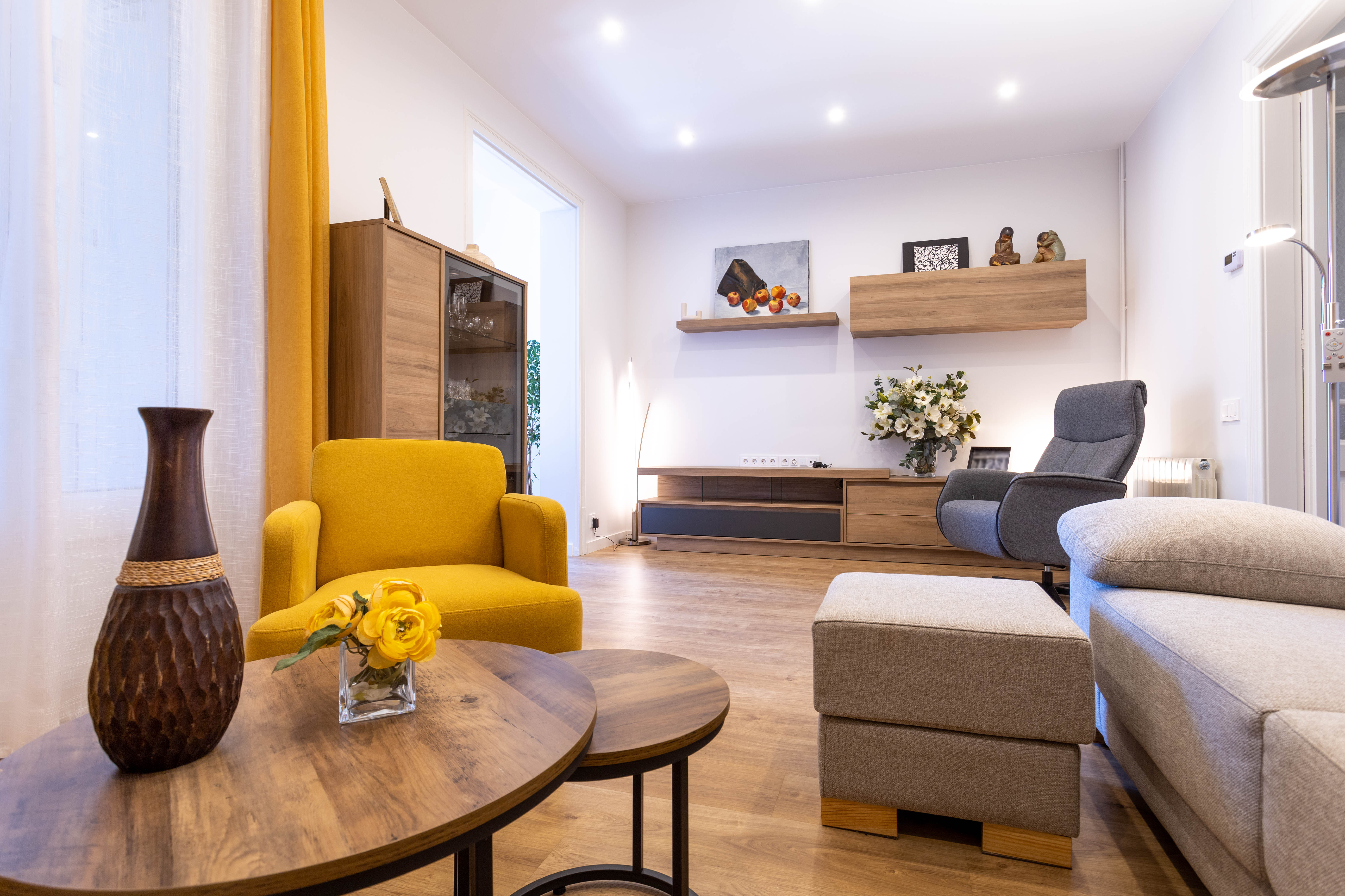 Salón con sillón amarillo y mueble de televisión